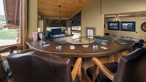 Un espace bar avec un comptoir en bois, des chaises et une vue sur l’extérieur.