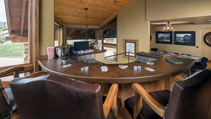 Un espace bar avec un comptoir en bois, des chaises et une vue sur l’extérieur.