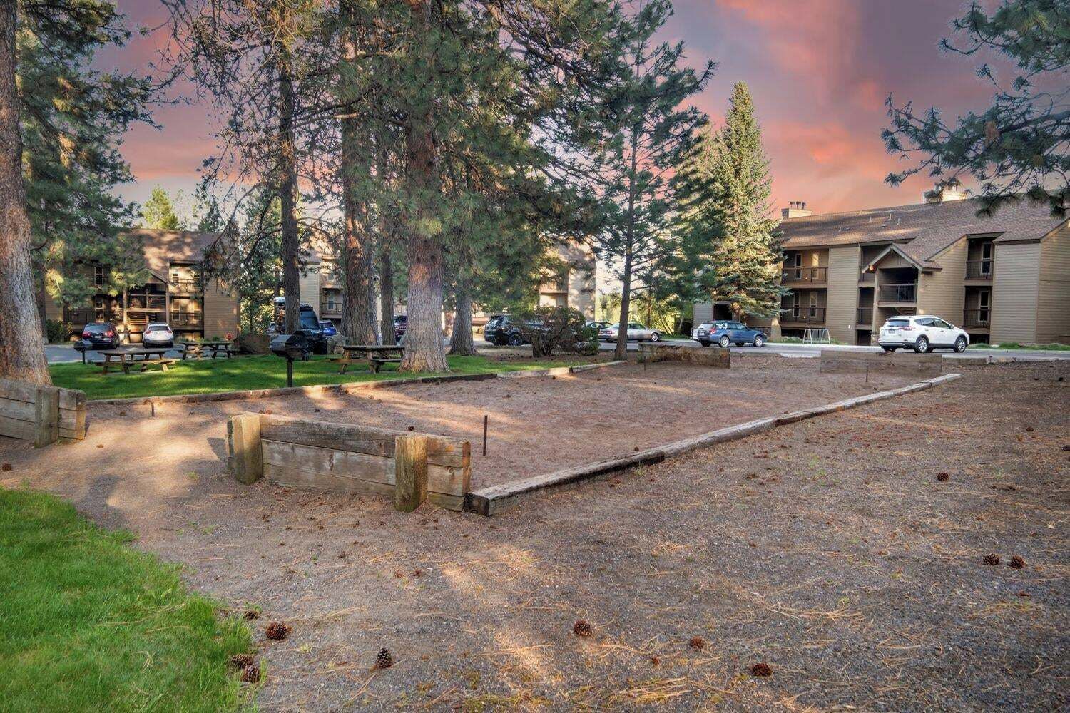 Un terrain de camping équipé de tables de pique-nique, d’un espace de pique-nique couvert et d’un bâtiment doté d’un toit plat.