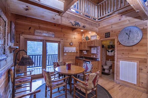Cozy cabin-style interior with a round dining table and kitchen area.