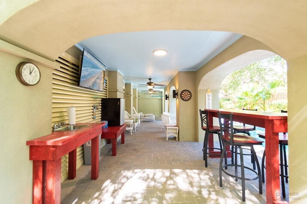 A corridor with a kitchen area, bar seating, and a dartboard.
