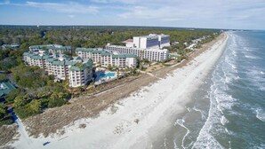 A coastal hotel with multiple buildings, a beach, and ocean views.