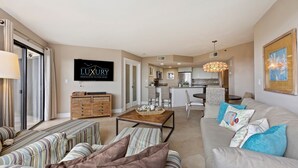 A spacious living area with a sofa, a coffee table, and a television displaying 'LUXURY RENTALS OF HILTON HEAD'.