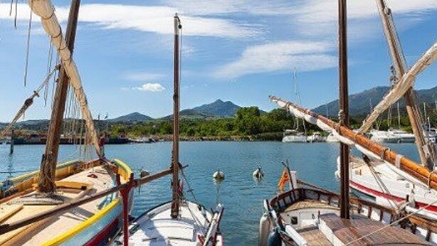 A harbor with several boats docked, a clear sky, and mountains in the background. - Cozy 2-Room Apartment with Terrace and Private Parking, 300m from Beach (Argelès-sur-Mer)