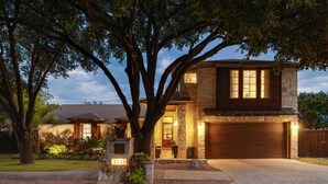 A two-story house with a stone facade, a garage, and a well-maintained lawn. - PRIVATE LUXURY HOME!!!  4mi to Downtown |4 Bedrm | 3 Bath | Sleeps 8 (Austin)