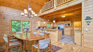 L’intérieur d’une cabane en bois comprend un coin repas, une cuisine et une chambre à coucher située en mezzanine.