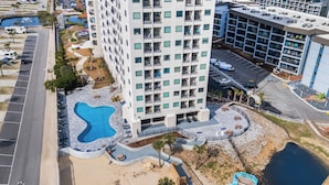 Una vista aerea di un hotel con diversi piani, una piscina e un'area parcheggio.