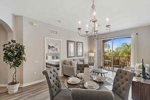 Relax in this inviting living area with a dining table, plush seating, and a large window offering a view of the outdoors.