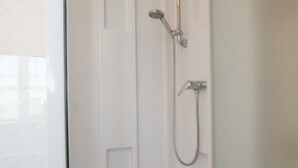 Puerta blanca con panel de control de ducha y cabezal de ducha manual.
