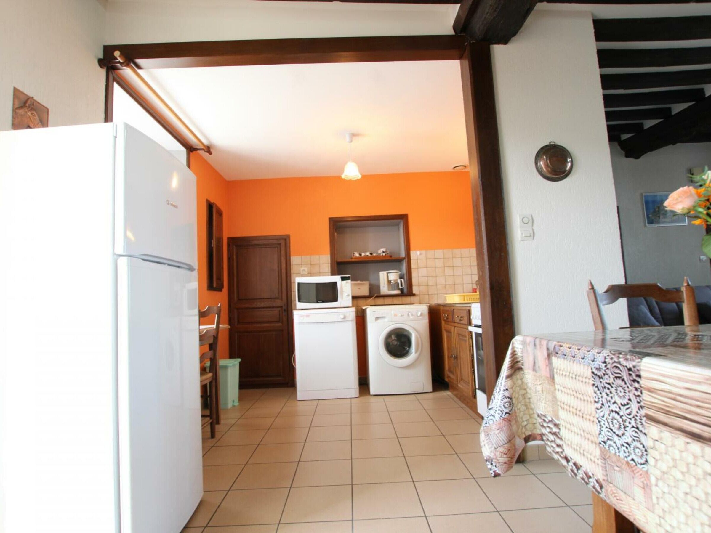A compact kitchen with a refrigerator, microwave, and washing machine.