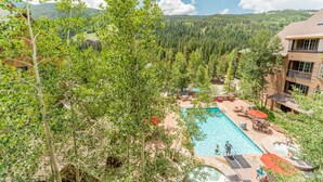 A resort with a pool, outdoor seating, and a mountainous backdrop. - River Run Condo w/ Mountain Views, Overlooks Shared Pool & Hot Tub! (Keystone)