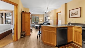 A spacious kitchen with wooden cabinets, a central island, and a built-in dishwasher. - River Run Condo w/ Mountain Views, Overlooks Shared Pool & Hot Tub! (Keystone)
