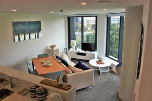 Panoramic-Apartment, Stadtblick | Wohnbereich | Flachbildfernseher