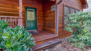 A wooden cabin with a green door, a porch, and a sign indicating a heritage point of view. - Point Of View - Spacious 2 Bedroom With a Loft Just off Glades Road (Gatlinburg)
