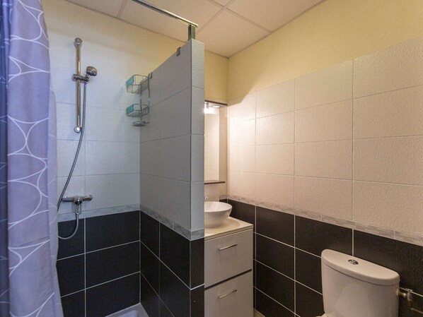 Un baño con ducha, inodoro y lavamanos.