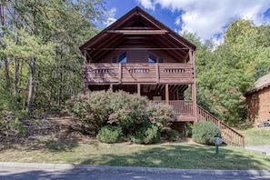 Escape to Alpine Life, where a cozy cabin awaits with a spacious porch and balcony amidst lush surroundings.