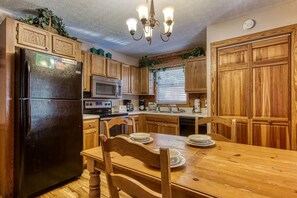 Enjoy cooking in this well-equipped kitchen with a central island, refrigerator, microwave, and stove.
