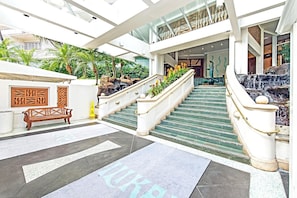Stunning lobby with a central staircase, plants, and geometric patterns.