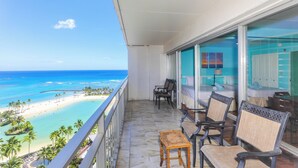 A balcony with a view of a beach and ocean. There are two chairs and a small table. - Experience luxury at Ilikai Tower - in the heart of Waikiki with stunning lagoon views. (Honolulu)