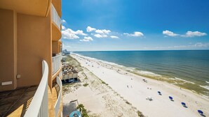 Un hotel frente a la playa con balcón con vistas a la playa, piscina y una vista despejada del océano.