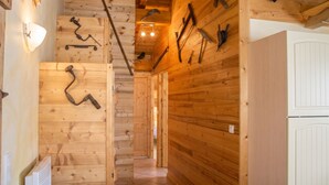A wooden interior with a hallway leading to a room with a white door.