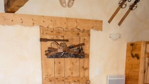 A wooden dining table with chairs, a wooden headboard with a coat rack, and a wooden cabinet.