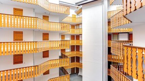Ein mehrstöckiges Gebäude mit Balkonen, ausgestattet mit Holzgeländern und Fenstern.