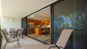 Una cocina moderna con armarios de madera, un refrigerador y un comedor con sillas y una mesa.
