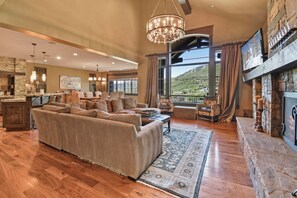 A spacious living area with a fireplace, large windows, and a view of a mountainous landscape.