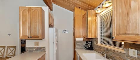 Kitchen with a window, refrigerator, and coffee maker.