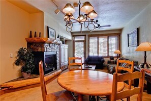 A cozy living room with a fireplace, wooden dining table, and comfortable seating. - Tl2112 Easy Mtn Living! Very Convenient Location! Winter Specials! (Steamboat Springs)