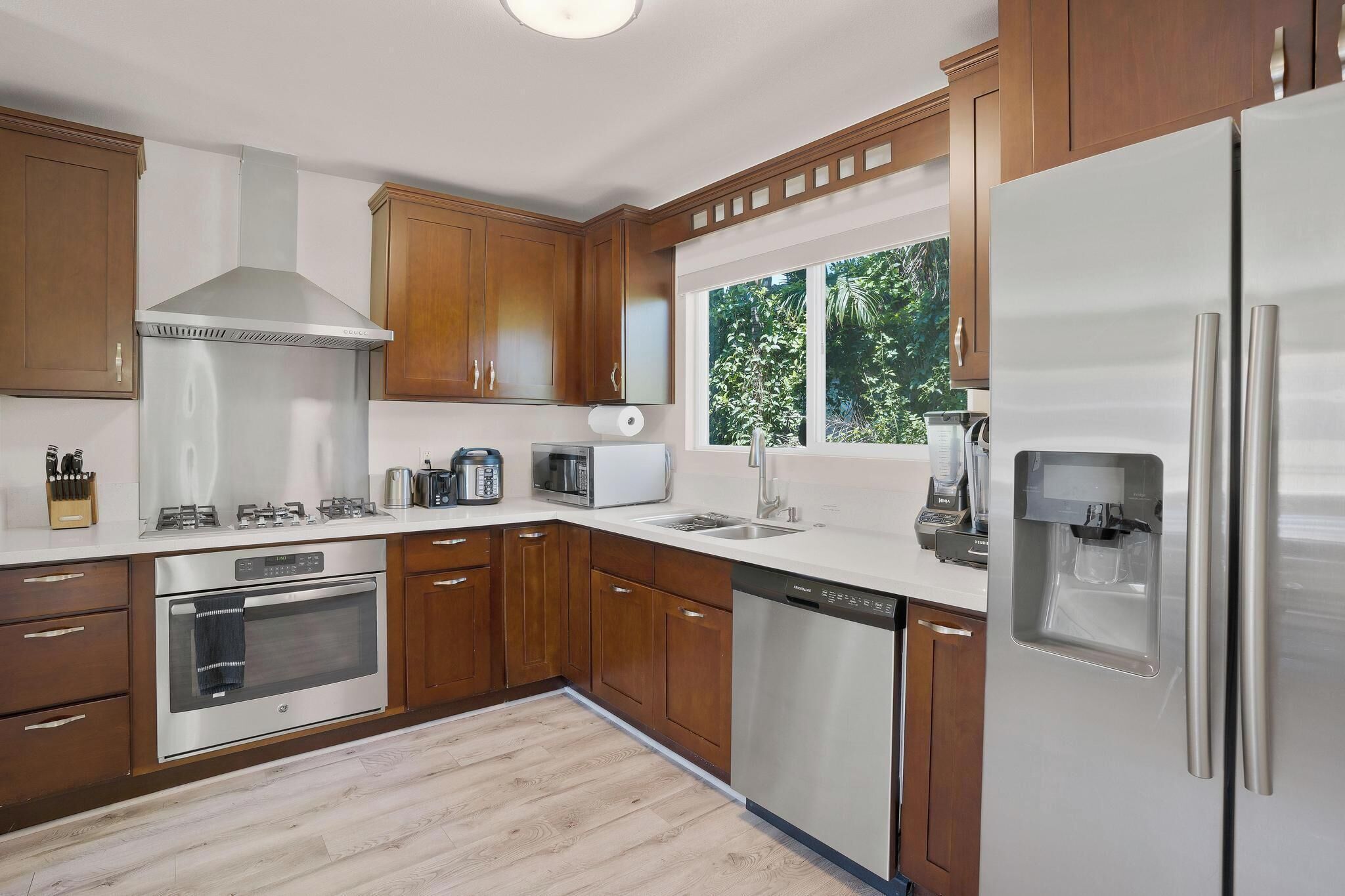 Una cocina moderna con armarios de madera, electrodomésticos de acero inoxidable y un dispensador de agua integrado.