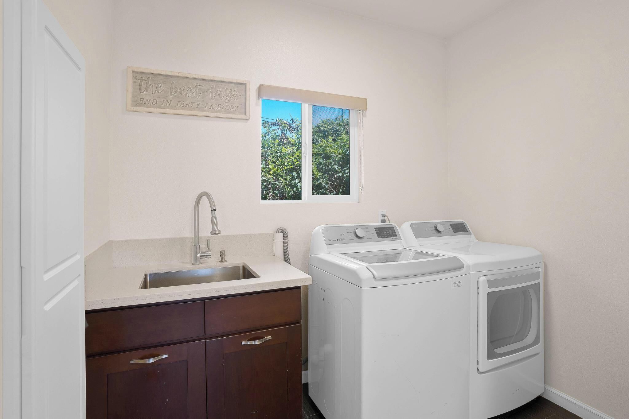 A laundry room with a washing machine and a sink.