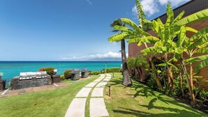 A pathway leading to a barbecue area with a view of the ocean.
