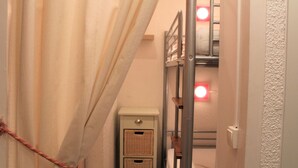A narrow hallway with a bunk bed, a small bedside table, and a curtain. - Charming Studio in Vars, 30m from Slopes, Sleeps 4 (Vars)