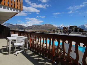 Un balcon avec vue sur les montagnes et une piscine.