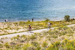 Cyclists enjoy scenic views of the sea along this coastal path lined with vibrant flowers and shrubs.