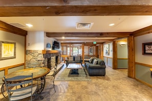 Cozy seating area with a stone fireplace, sofa, and chairs, perfect for relaxing.