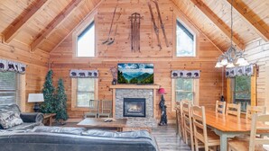 A cozy cabin interior with a fireplace, wooden furniture, and a Christmas tree. - ER101 - Heavenly Hideaway  Great location - Close to town! (Pigeon Forge)