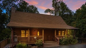 A log cabin with a porch, steps leading to the entrance, and a driveway. - ER101 - Heavenly Hideaway  Great location - Close to town! (Pigeon Forge)