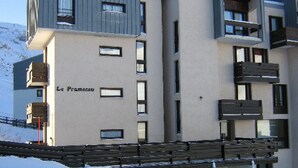A multi-story building with balconies and a sign that reads "Le Pramecau."