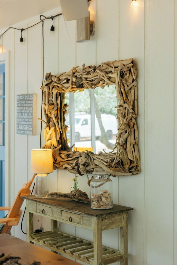 A rustic wooden console table with a mirror, a lamp, and a glass jar with shells. - Moon Baby 2 bed 2 bath - Grayton, Red Bar (Santa Rosa Beach)