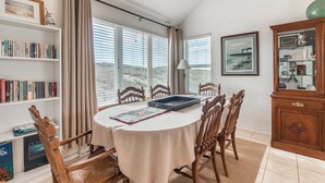 A dining area with a round table, chairs, a bookshelf, and a cabinet.