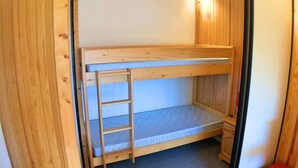 A bunk bed with a ladder, wooden walls, and a small red box in the corner. - Charming 2-Room Cabin Apt, 40m², Sleeps 4, Near Vars Les Claux Slopes (Vars)