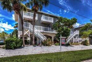 A two-story house with a balcony, a staircase, and a 'For Sale' sign. - Fountain Head 8 - Condo 2 Bedroom / 2 Bath , maximum occupancy of 6 people. Holmes Beach Anna Maria Island (Holmes Beach)