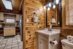 Ein Holzblockhaus-Interieur mit Küche, Bad und einem großen Spiegel.