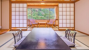 A traditional Japanese room with tatami flooring, a low wooden table, and two tatami mats with cushions. - Hakoneji Kaiun (Hakone)