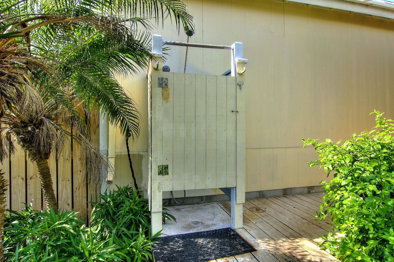 A wooden gate with a metal handle, a concrete step, and a metal door frame.