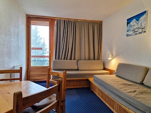 Een gezellige kamer met een houten bankje, een tafeltje en een bank.