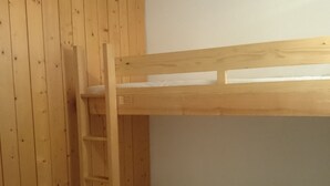 A bunk bed with a wooden ladder, white mattress, and a wooden wall. - Studio for 4, ski-in/ski-out, Arc 1800 (Les Arcs 1800)